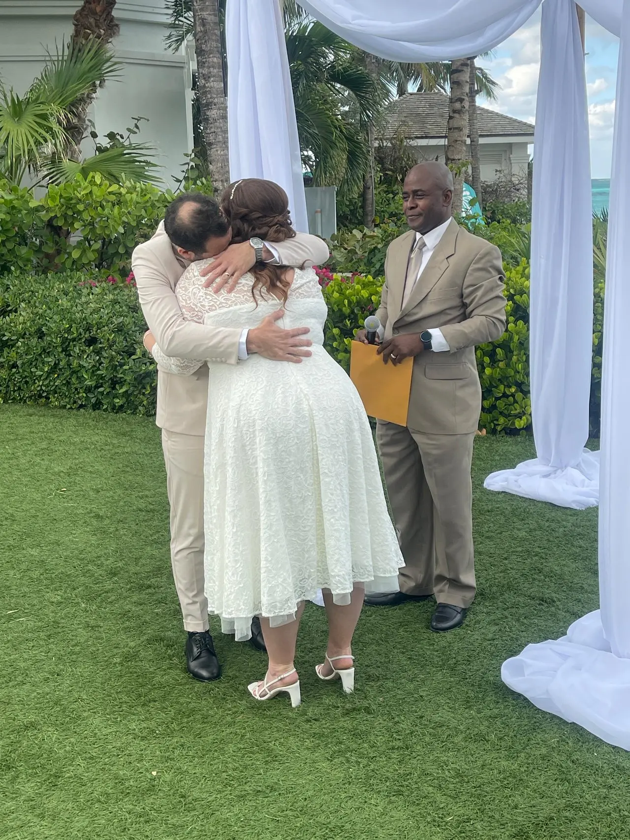 A garden ceremony, Antonio officiating as the couple embrace